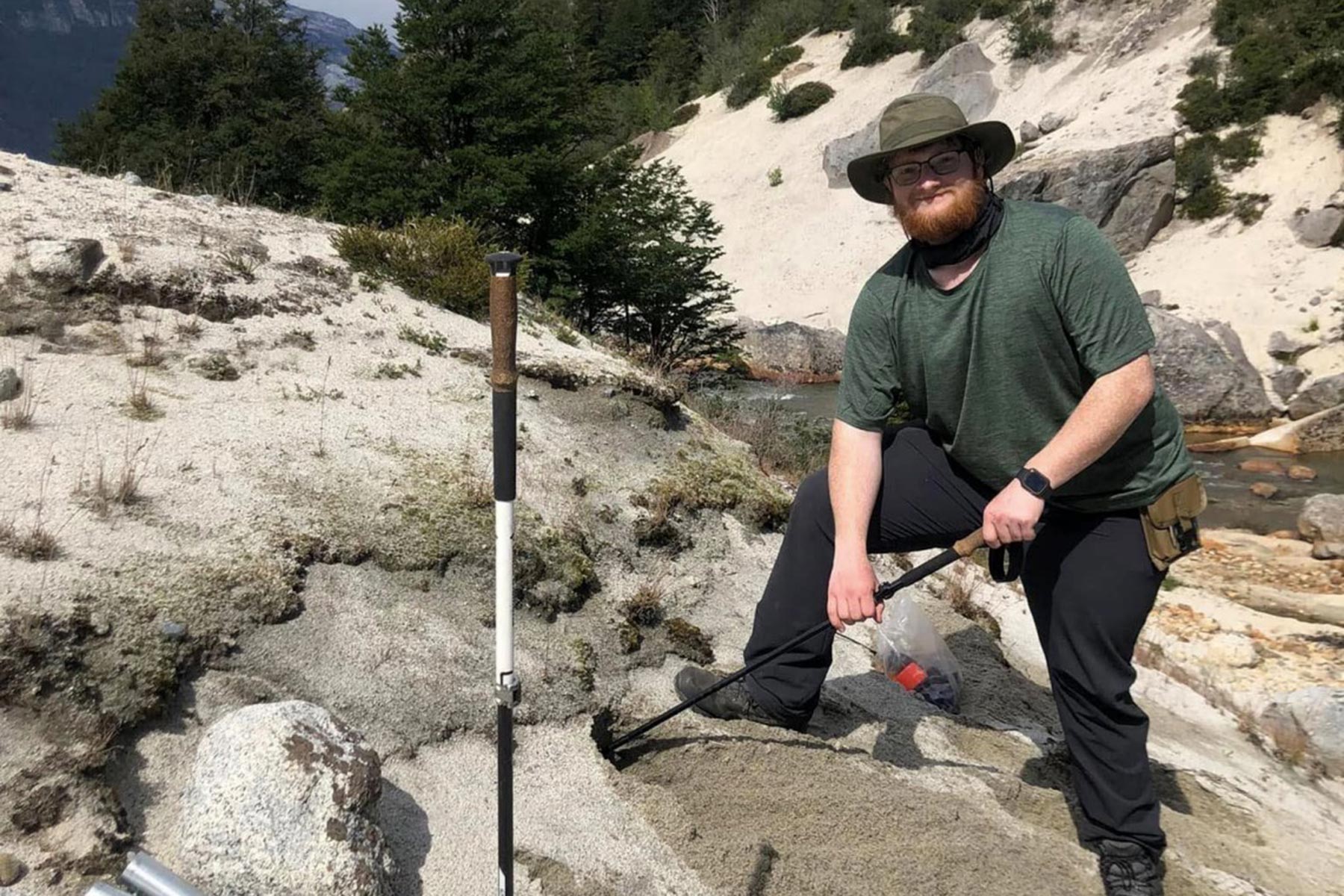 garrett ohara standing on a large rock in a river